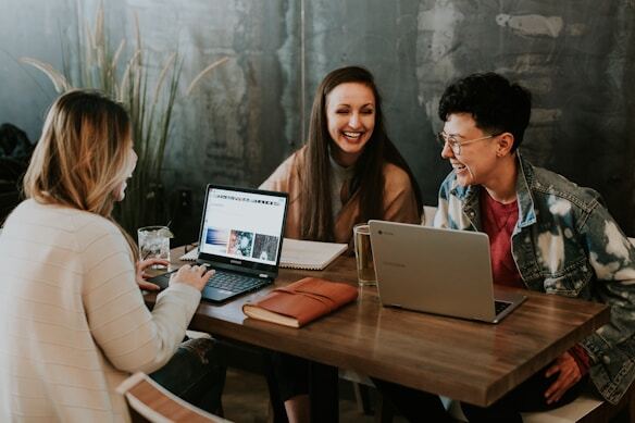 Group of people with laptop and having happy conversation